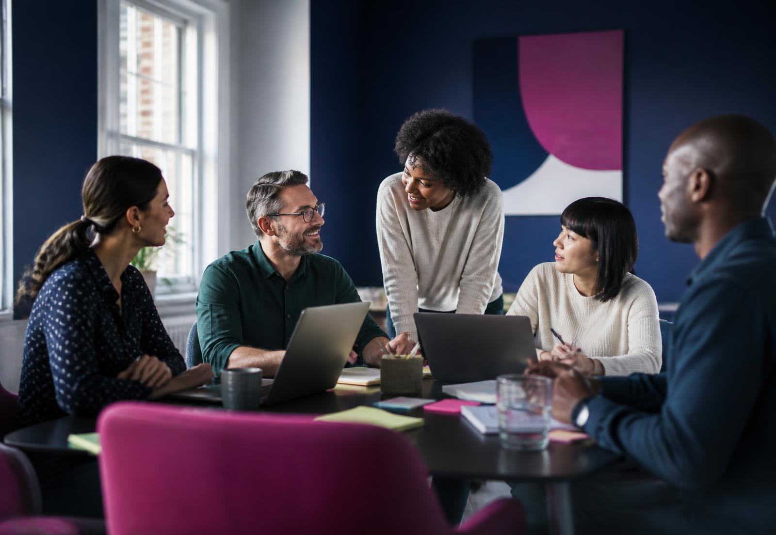 A team of colleagues collaborating around a table in a bright office
